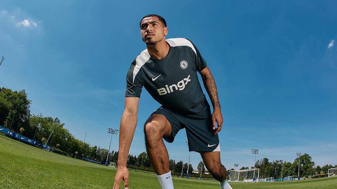 Chelsea speler in een donkergroen Nike trainingsshirt tijdens een voetbaltraining buiten op natuurgras