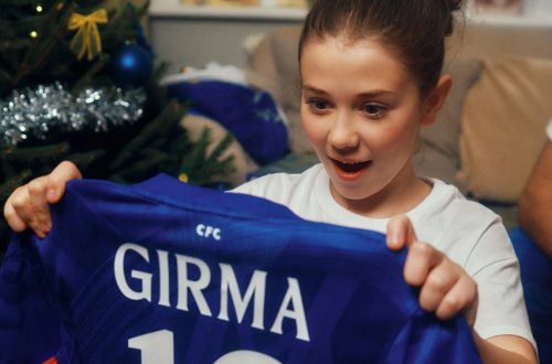 Jonge voetbalfan ontvangt een Chelsea shirt als cadeau en reageert enthousiast tijdens de feestdagen